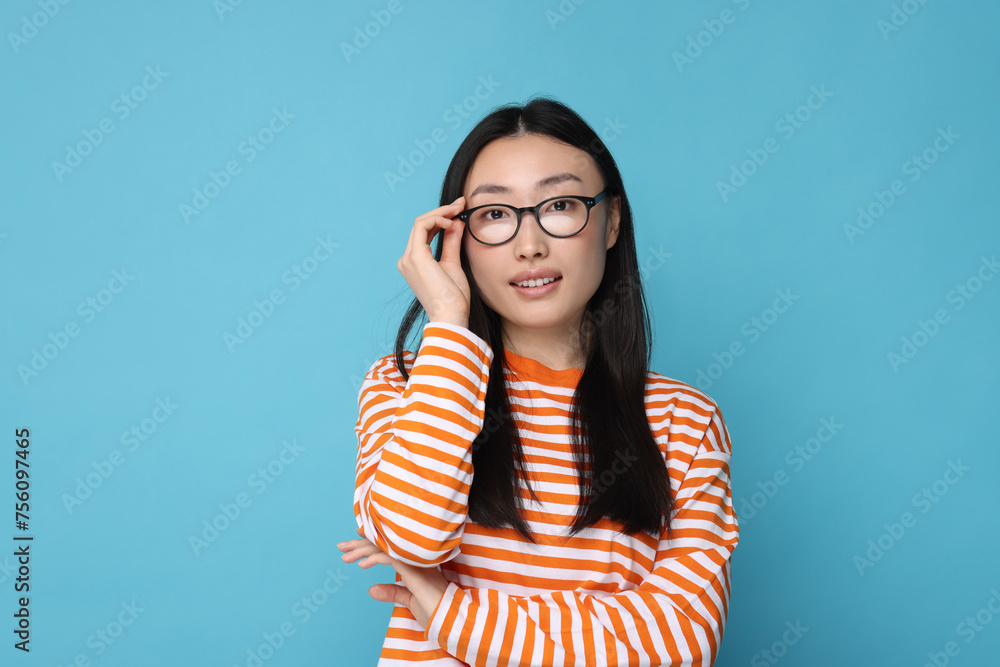 Portrait of happy woman in glasses on light blue background Portrait of happy woman in glasses on light blue background