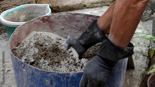 Caucasian senior adult man mixing cement and sand for construction with the help of a trowel. Walls, building, house.