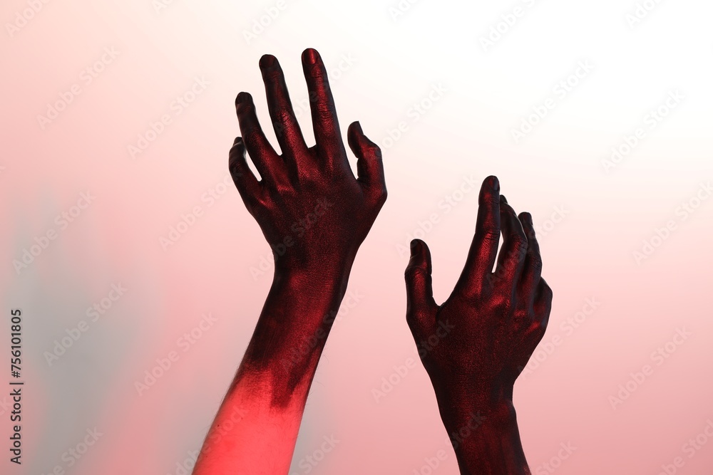 Woman with hands painted in black color on white background, closeup