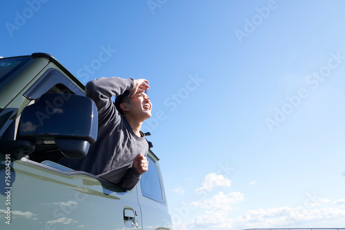 車の助手席の窓から体を乗り出す男性 photo