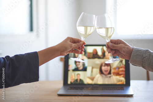 男女が乾杯をする手とリモート飲みをするパソコンの画面 photo