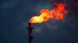 A flare stack burning off excess natural gas creating a bright flame and loud roaring noise.