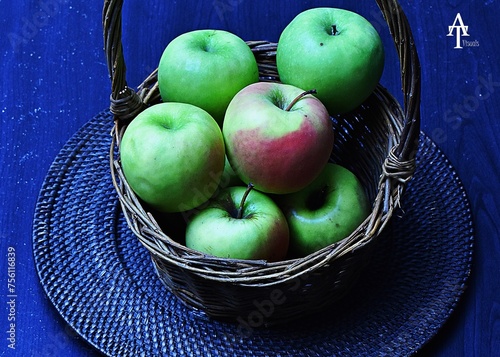 Green granny smith apples in a brown wooden basket. (ID: 756116839)