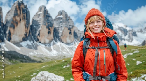 Energetic young blonde woman smiling while hiking on a mountain trail with space for text