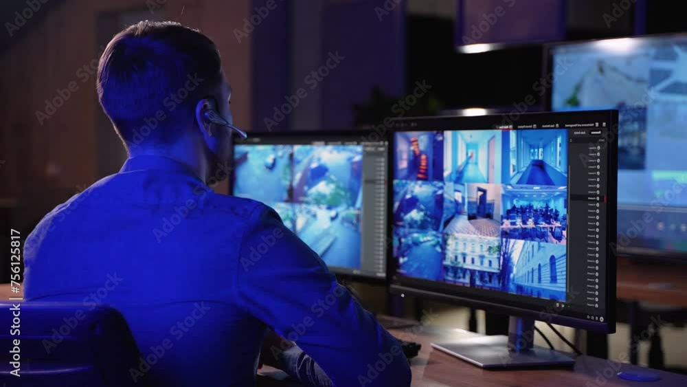 Security Guard Works on a Computer with Surveillance CCTV Video Footage in a Monitoring Center with Multiple Cameras on a Big Digital Screen. Employees Sit in Front of Displays with Big Data Security Guard Works on a Computer with Surveillance CCTV Video Footage in a Monitoring Center with Multiple Cameras on a Big Digital Screen. Employees Sit in Front of Displays with Big Data
