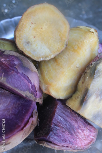 Boiled purple and yellow sweet potatoes in a plate on the table