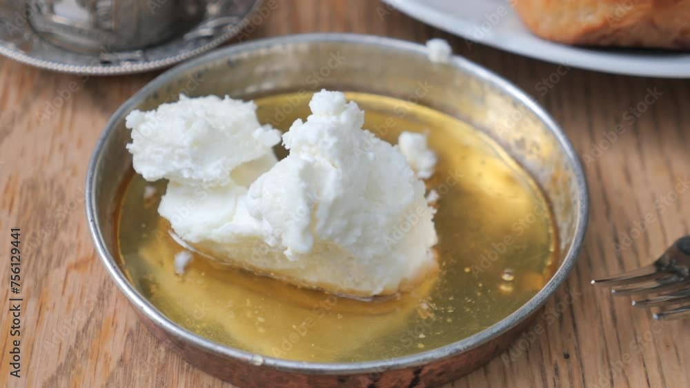 butter cream and honey in a bowl on table . butter cream and honey in a bowl on table .
