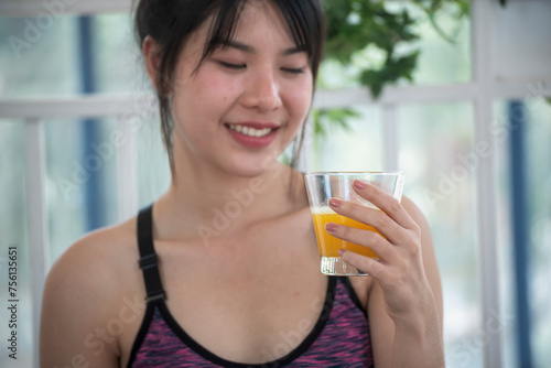 Asian women smile laugh look at camera health care home fitness lifestyle. Women hands holding cold orange juice fresh fruit cool drinking. Beautiful female pouring orange juice from cocktail bottle