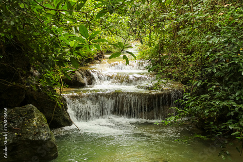 Jungle landscape with flowing turquoise water of Erawan cascade waterfall