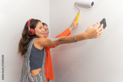 Friends talking a selfie while painting the apartment together