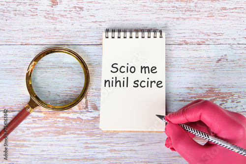 Scio me nihil scire It is translated from Latin as I know I don't know anything. written in pencil on a notebook photo