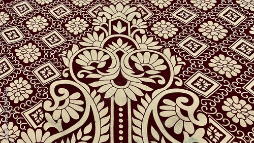 Close-up of a brown and white pattern on a table, placed on a red velvet cloth, shades of dark red and ecru. Detailed intricate block printing, Art Nouveau floor patterns, velvet art, Greek fabrics