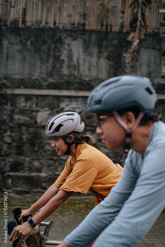A young couple riding their bikes in the city.