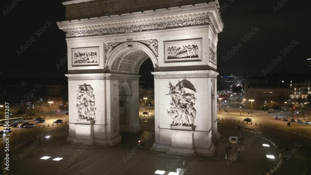 Triumphal arch illuminated at night, Paris in France. Aerial circling
