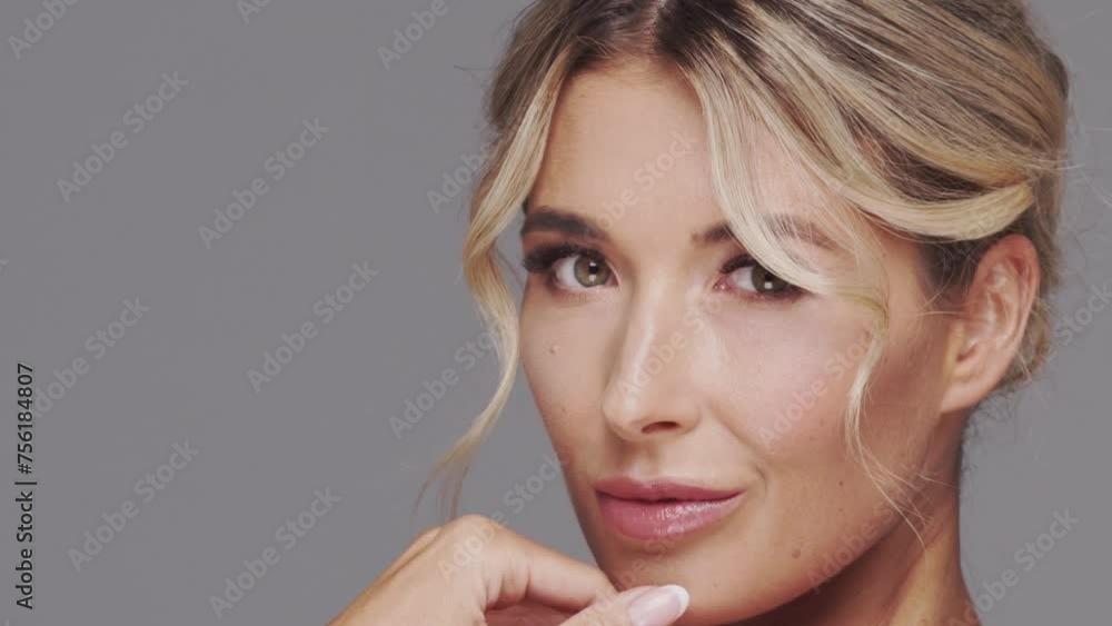 Studio portrait of young and beautiful blond woman over grey background. Skin care and wellness concepts.