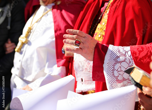 Bild auf Leinwand Bishop s hand in clerical attire blessing nuns standing before him