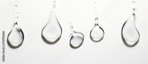 Panel kuchenny z motywem Liquid silver drops on a white surface, like body jewelry for a minimalist art piece. The metallic circle forms a delicate twig design