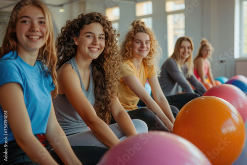 Happy young people sitting on balls after physical classes in the studio