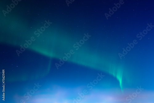 Green Aurora borealis or polar lights on night blue sky