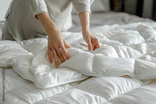 Woman is putting the bedding cover or mattress pad on the bed or putting off for cleaning process