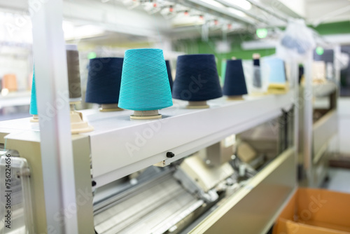 in the weaving factory There is a sewing machine and several spools of thread placed above, ready for use in the large-scale industrial production of clothing for export to the world market.