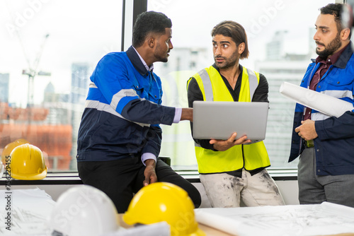 Professional of team architect industrial engineer cargo foreman in helmet working new construction project architectural plan with blueprint and construction tool at the building construction site