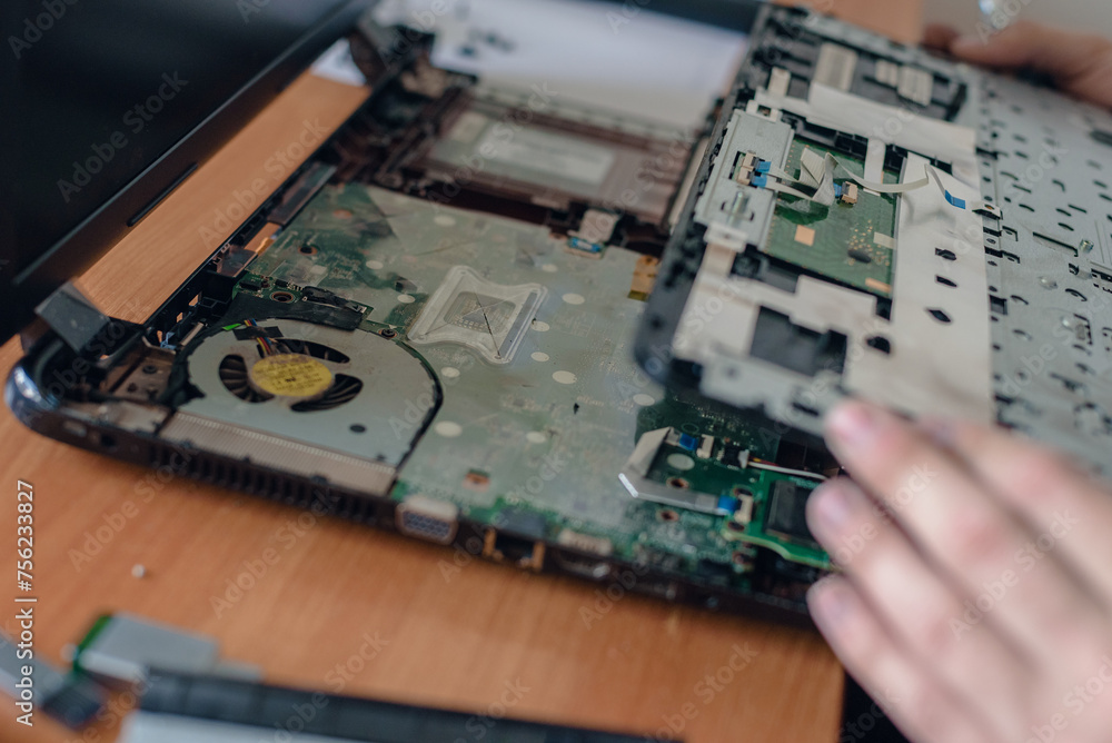 Closeup of specialist hands cleaning old laptop from dust, Laptop TLC: Skilled technician provides thorough repair and cleaning, restoring the device's vitality Closeup of specialist hands cleaning old laptop from dust, Laptop TLC: Skilled technician provides thorough repair and cleaning, restoring the device's vitality
