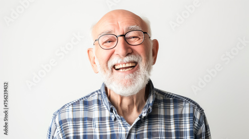 An old man with a beard and glasses is smiling and wearing a plaid shirt