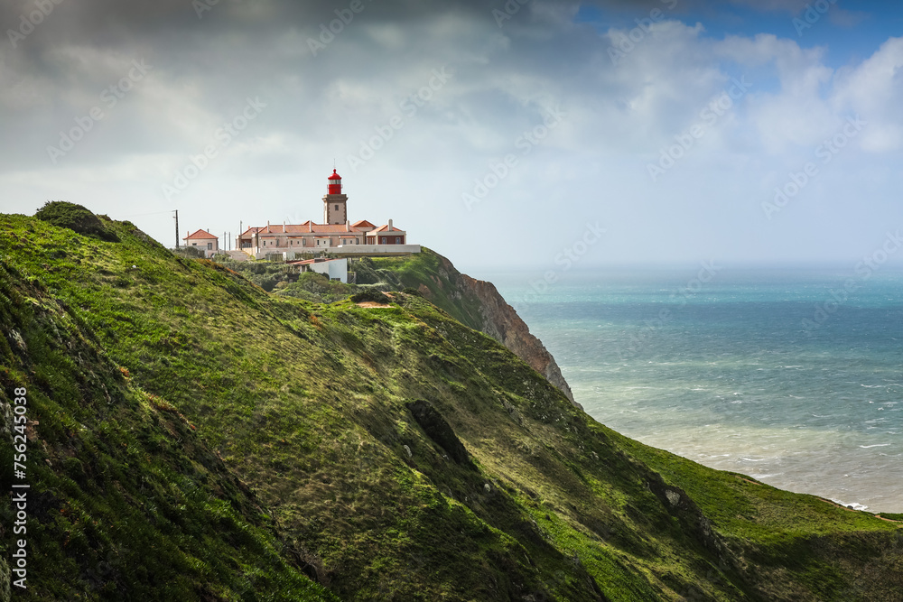 Cabo da Roca western point of Europe in Portugal at Atlantic Ocean photo during a beautiful sunny day. Amazing color of ocean water, view to lighthouse. Travel to Portugal.