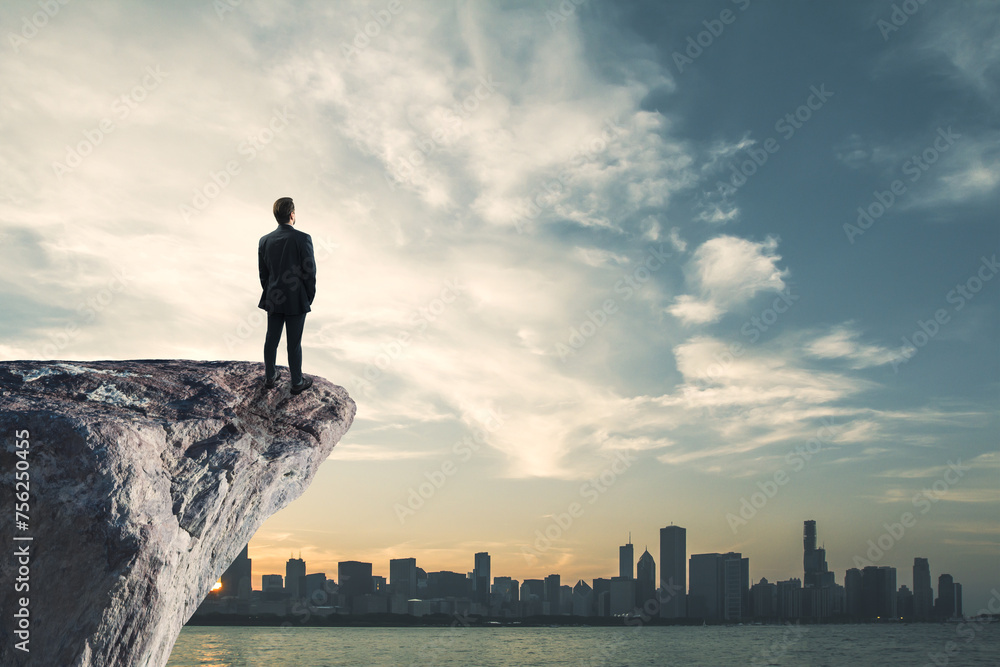 Businessperson standing on cliff edge on bright blue sky with mock up place background. Future, success and tomorrow concept.