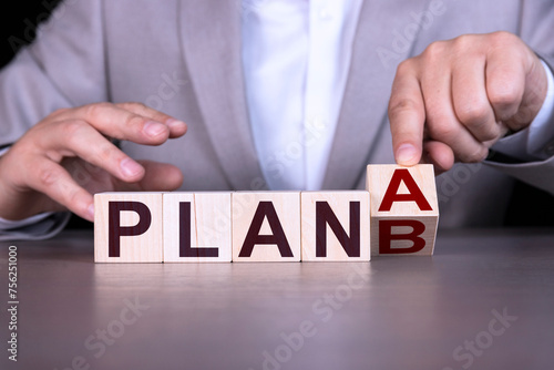 Wallpaper Mural A businessman in a gray suit holds cubes with the words PLAN A, Plan B. The concept of business and choice. Torontodigital.ca