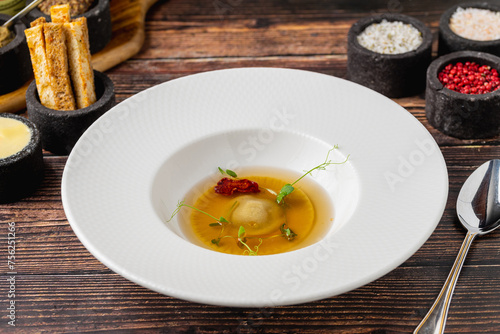 Ravioli consomme on a white porcelain plate. Healthy eating concept