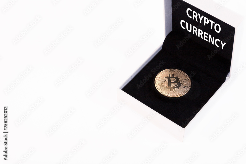 Cryptocurrency text, golden bitcoin in a white gift box with black velvet on a white background. Copy space. Cryptocurrency text, golden bitcoin in a white gift box with black velvet on a white background. Copy space.