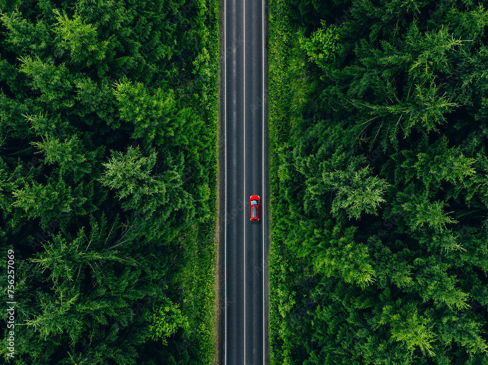 Aerial view of car with a roof rack on a country road and green woods in Finland Aerial view of car with a roof rack on a country road and green woods in Finland