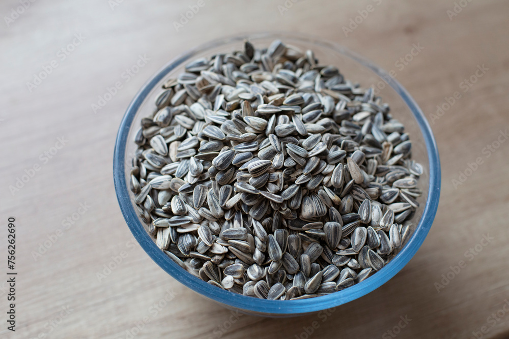Close-up on roasted striped sunflower seeds on a wooden table. Eating natural foods