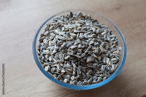 Close-up on roasted striped sunflower seeds on a wooden table. Eating natural foods