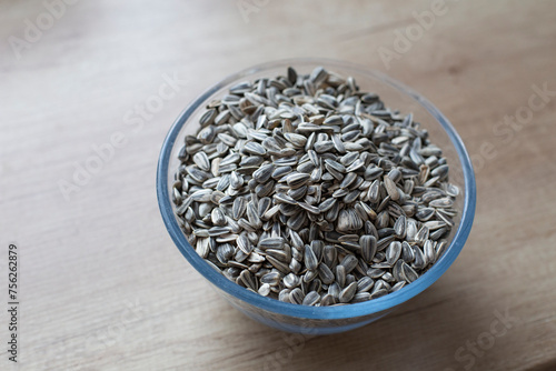 Striped fried sunflower seeds on the table in a transparent plate