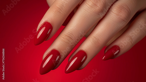 Red manicure on the red background  Nail service concept