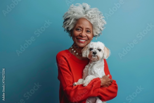 portrait of an elderly black afro american woman holding a little dog in her hands photo