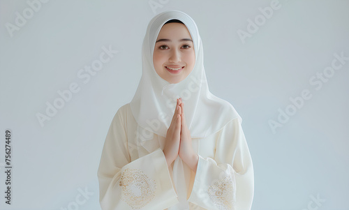 Indonesian woman in hijab is raising her hands while smiling on a white background (ID: 756274489)