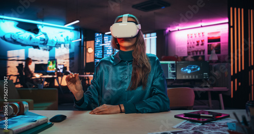 Portrait of Young Adult Female Using Virtual Reality Goggles in Creative Office. Woman Using Futuristic Augmented Reality Software for Managing Business and Marketing Projects