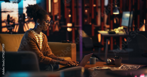 Portrait of Black Female Working in Empty Creative Agency, Implementing Modern Business Strategy for Clients. Successful Game Developer Using Laptop Computer at Night in the Office