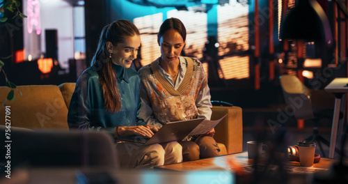 Two White Females Having a Discussion in Meeting Room Behind Glass Walls in an Agency. Creative Director and Project Manager Compare Business Results and App Designs on Laptop in an Office