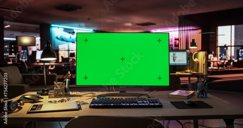 Desktop Computer with Mock Up Green Screen Chroma Key Display Standing on the Desk in the Empty Creative Office Lit by Neon Lights. Monitor in Game Development or Animation Company © Gorodenkoff
