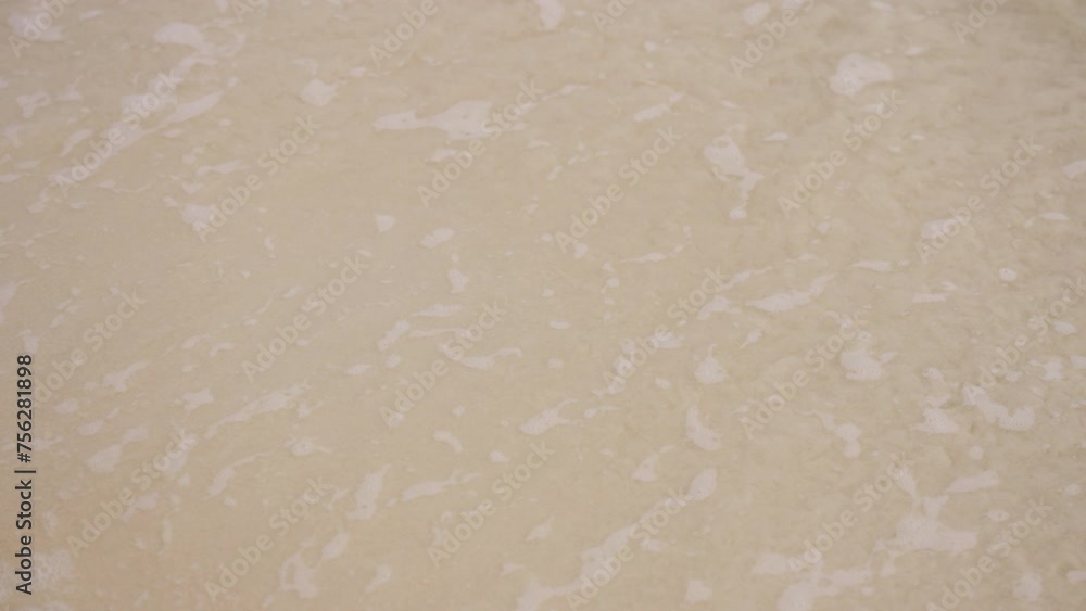 A captivating close-up reveals soft ocean waves gently caressing golden sands, creating mesmerizing ripples. The tranquil scene captures the serene beauty of the beach. High quality 4k footage A captivating close-up reveals soft ocean waves gently caressing golden sands, creating mesmerizing ripples. The tranquil scene captures the serene beauty of the beach. High quality 4k footage