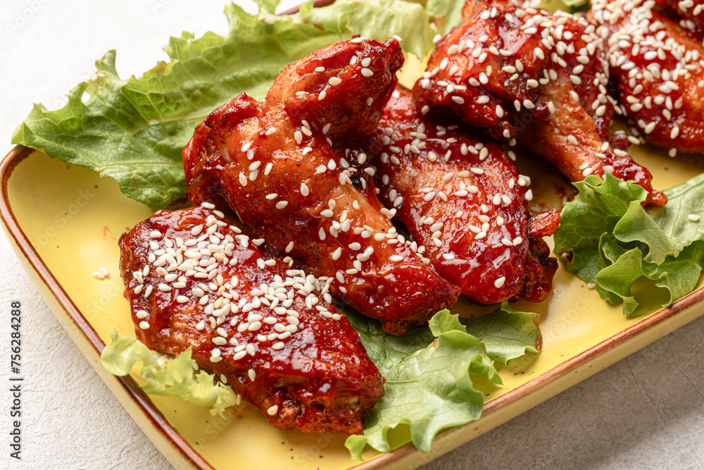 Portion of cooked chicken wings in sauce and sesame seeds Portion of cooked chicken wings in sauce and sesame seeds
