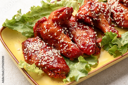 Portion of cooked chicken wings in sauce and sesame seeds