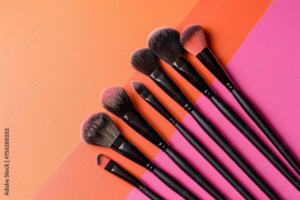 still life makeup brushes and powder on pink and orange background