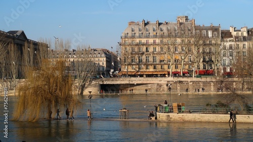 Inondation des quais de la ville de Paris, le fleuve de la Seine en crue en février 2018, avec des piétons au bord de l’eau, sur la pointe du square du Vert-Galant inondée, île de la Cité (France)