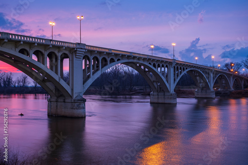 The sunsets behind the Lincoln Memorial Bridge spanning the Wabash River in Vincennes, Indiana photo